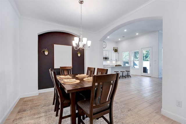 dining area featuring crown molding and a notable chandelier