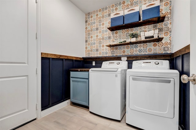 clothes washing area with cabinets and independent washer and dryer