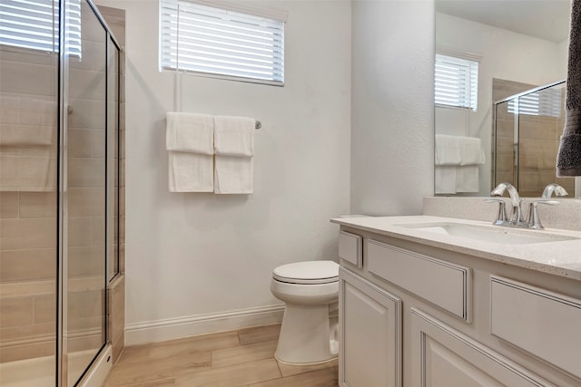 bathroom featuring toilet, hardwood / wood-style floors, vanity, and walk in shower