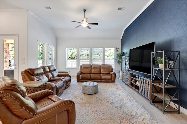 living room featuring ceiling fan, light wood-type flooring, ornamental molding, and vaulted ceiling