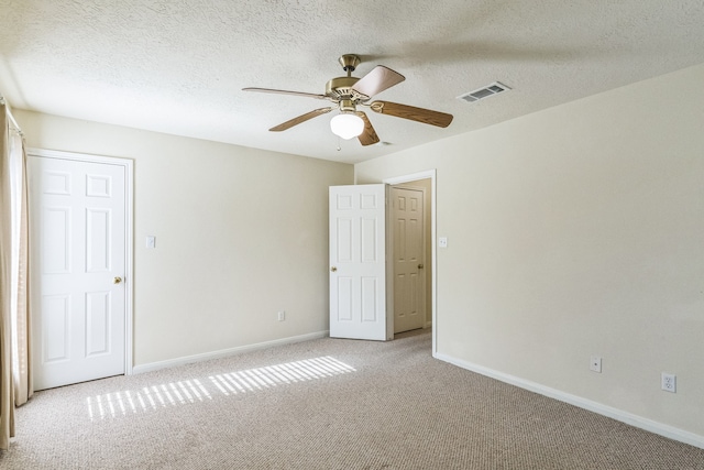 carpeted spare room with ceiling fan and a textured ceiling