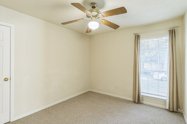 unfurnished room featuring light colored carpet and ceiling fan