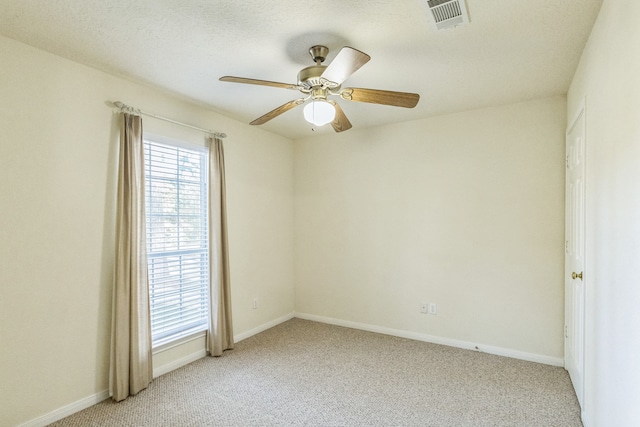 carpeted spare room with ceiling fan and a textured ceiling