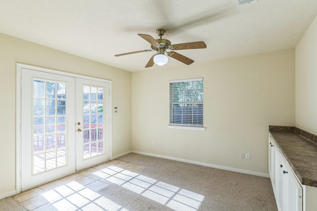 entryway featuring light carpet, french doors, ceiling fan, and a textured ceiling