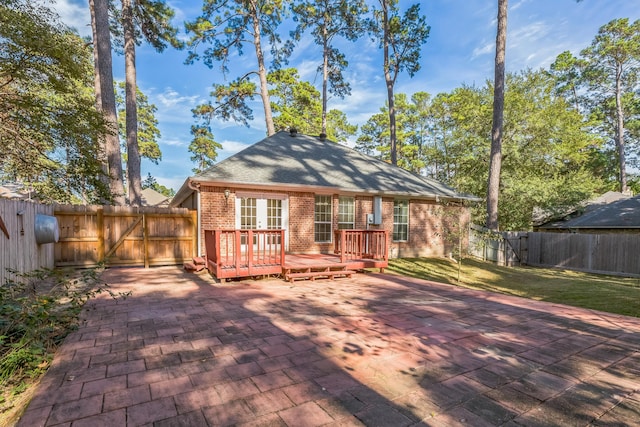 rear view of house featuring a lawn, a patio area, and a deck