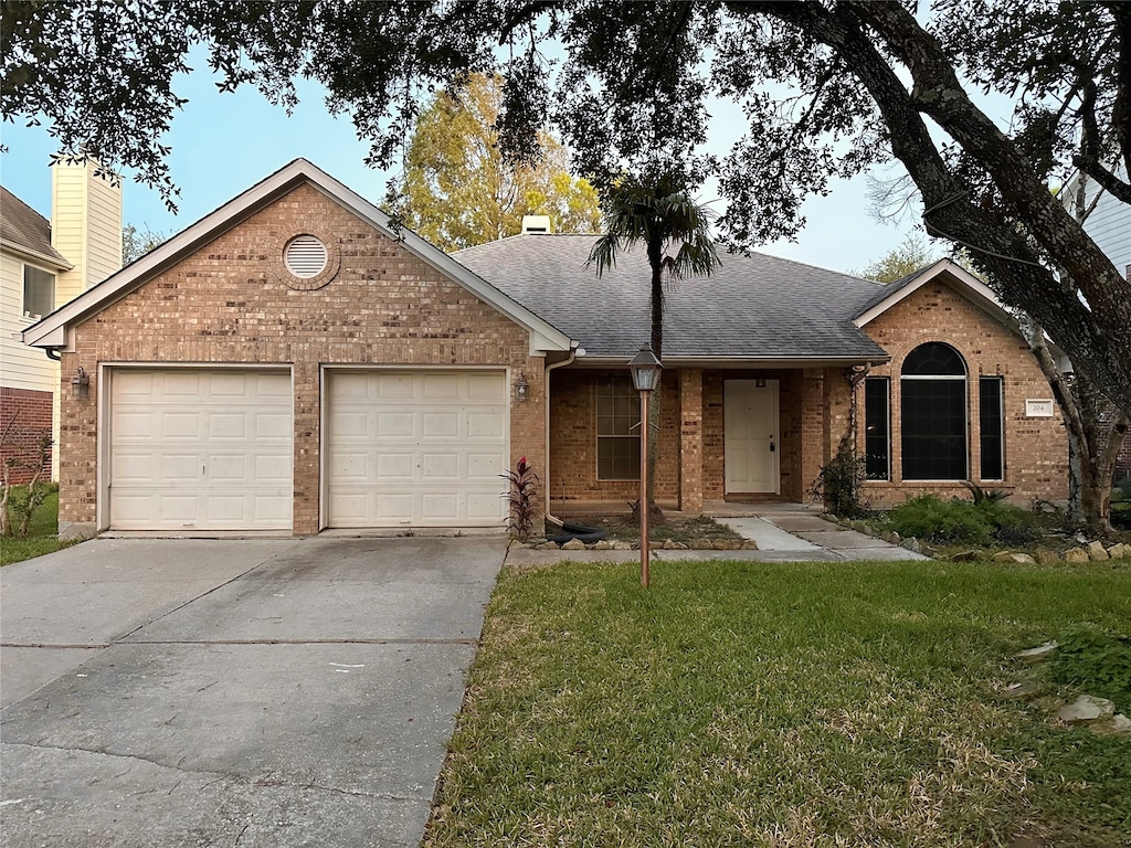 single story home with a front yard and a garage