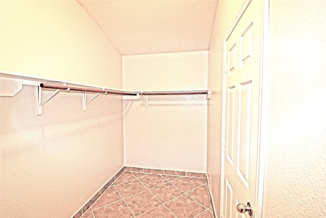 walk in closet featuring tile patterned floors and vaulted ceiling