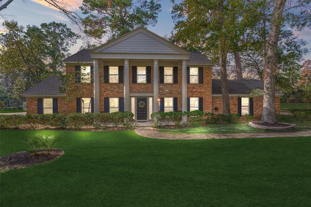 greek revival house featuring a yard