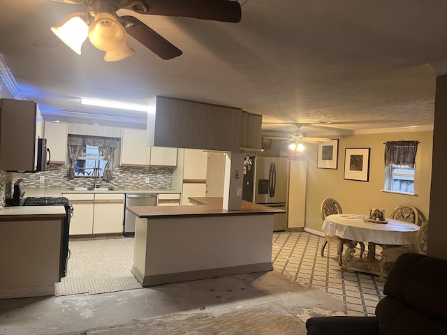 kitchen with decorative backsplash, appliances with stainless steel finishes, a textured ceiling, ceiling fan, and white cabinets