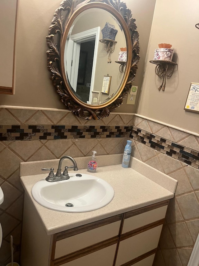 bathroom with vanity and tile walls