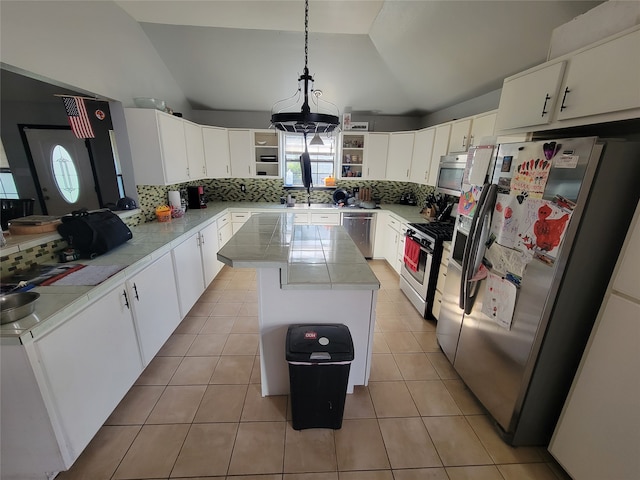 kitchen featuring a wealth of natural light, white cabinetry, stainless steel appliances, pendant lighting, and lofted ceiling