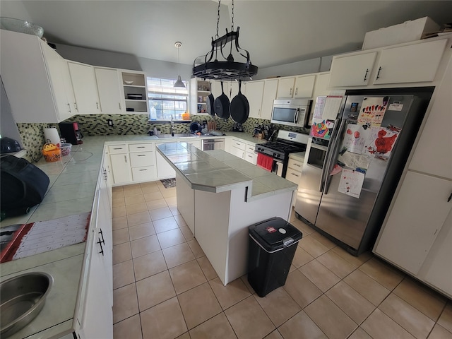 kitchen with appliances with stainless steel finishes, sink, pendant lighting, a center island, and white cabinetry