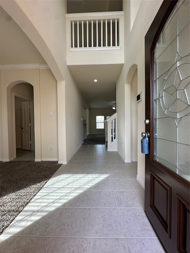 tiled foyer entrance featuring a high ceiling and ornamental molding