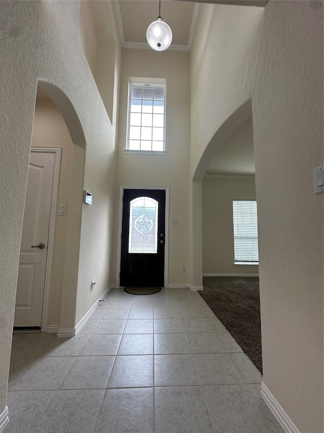 tiled entrance foyer featuring a high ceiling and ornamental molding