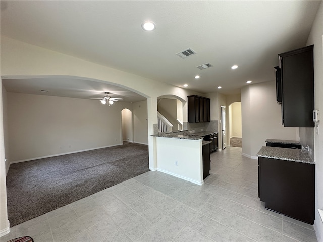 kitchen with light carpet, stone counters, and ceiling fan