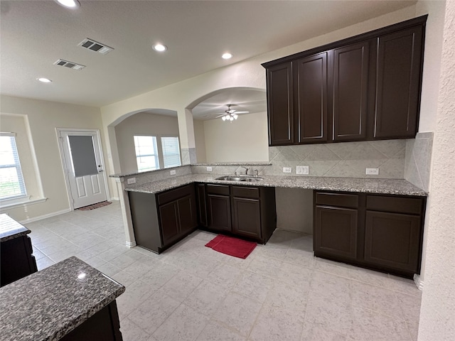 kitchen featuring plenty of natural light, ceiling fan, dark brown cabinetry, and decorative backsplash