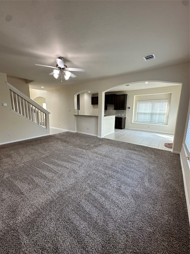 unfurnished living room with ceiling fan and light carpet