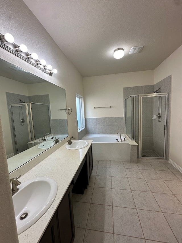 bathroom with tile patterned flooring, shower with separate bathtub, a textured ceiling, and vanity