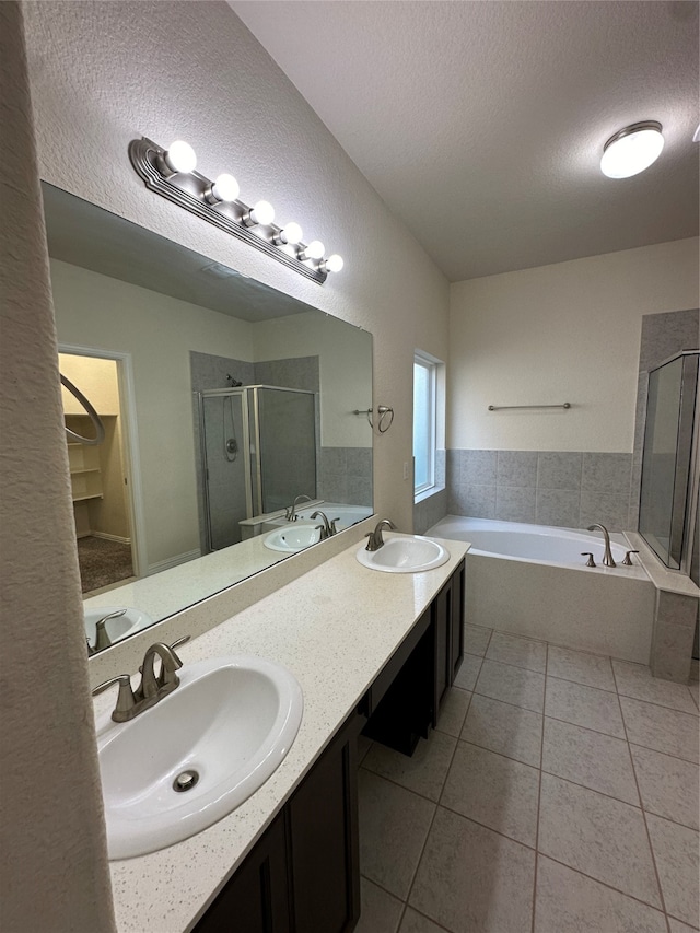 bathroom featuring tile patterned flooring, vanity, separate shower and tub, and a textured ceiling