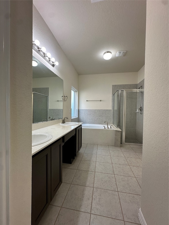 bathroom with tile patterned floors, vanity, a textured ceiling, and shower with separate bathtub