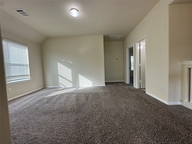 unfurnished room featuring dark carpet and lofted ceiling