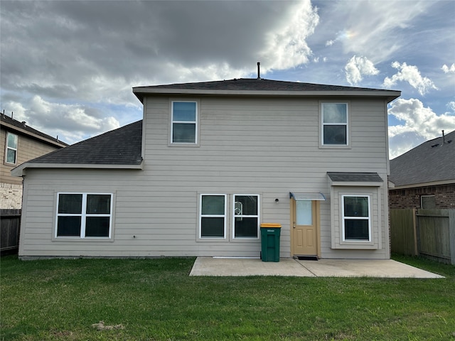 back of house with a patio and a lawn