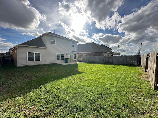 back of house featuring a lawn and a patio