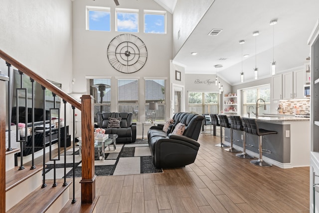 living room featuring sink and high vaulted ceiling