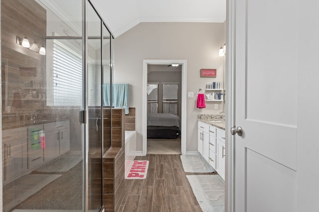 bathroom featuring crown molding, a shower with door, vanity, and vaulted ceiling