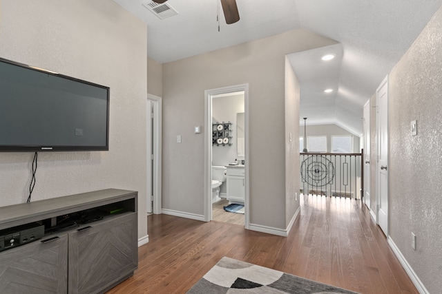 hall with light hardwood / wood-style floors and vaulted ceiling