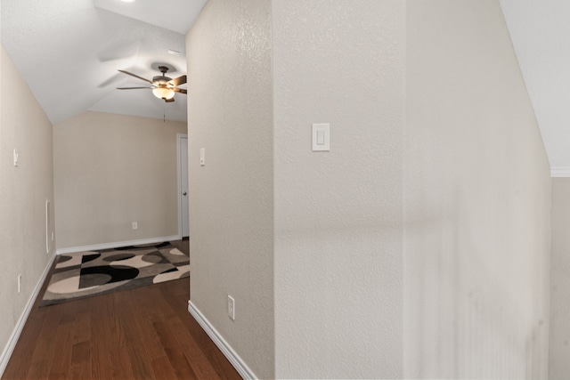 hallway with dark wood-type flooring and lofted ceiling