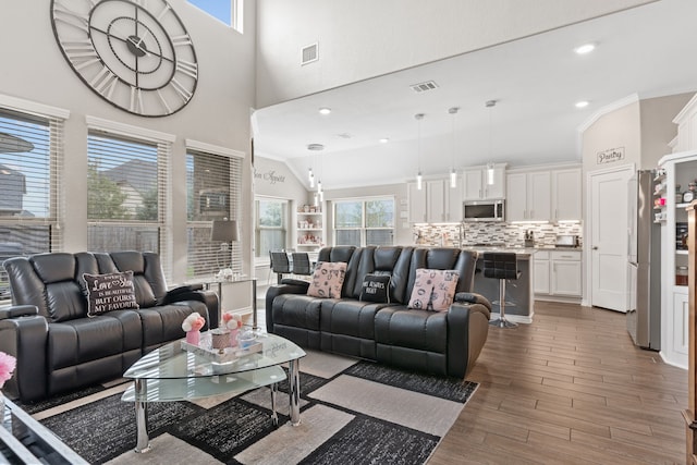 living room featuring ornamental molding and vaulted ceiling