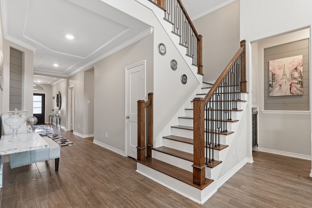 stairs with hardwood / wood-style floors and ornamental molding