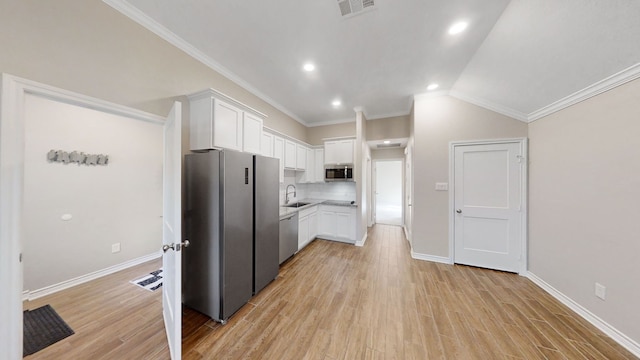 kitchen featuring white cabinets, stainless steel appliances, crown molding, and sink