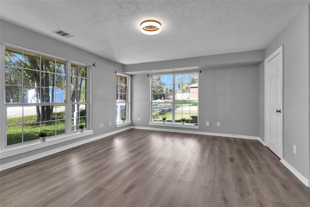 spare room with wood-type flooring and a textured ceiling