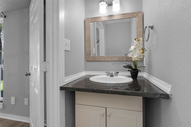 bathroom featuring vanity, wood-type flooring, and a textured ceiling