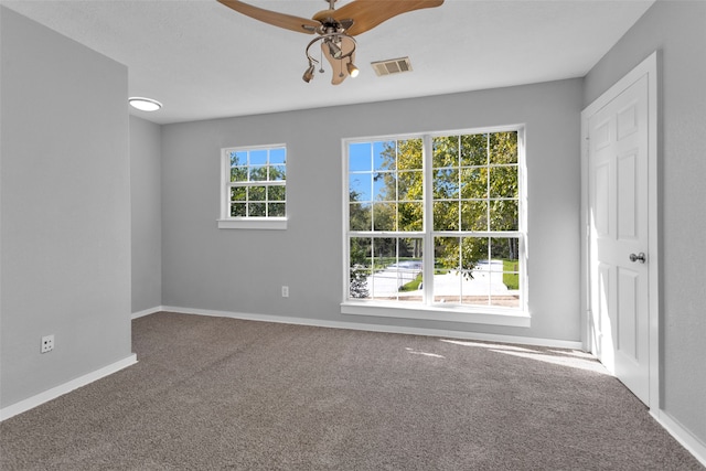 carpeted spare room with ceiling fan and a healthy amount of sunlight