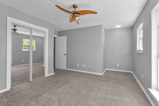 unfurnished bedroom featuring carpet, a closet, and ceiling fan