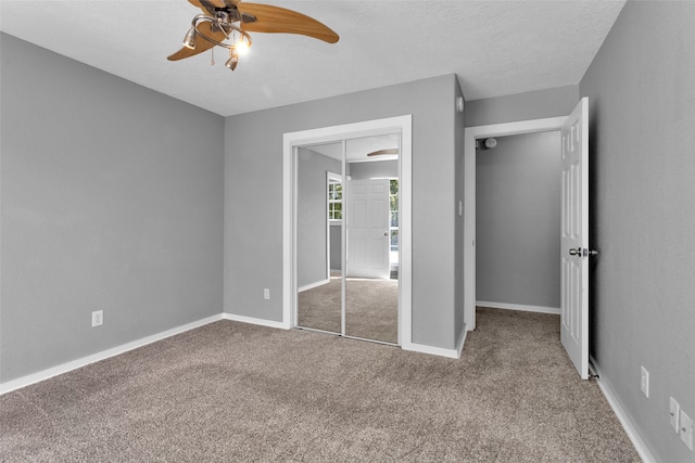 unfurnished bedroom featuring carpet flooring, a textured ceiling, a closet, and ceiling fan