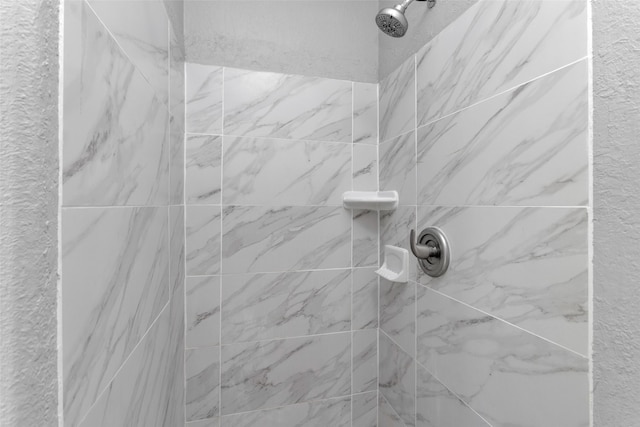 interior details with a tile shower