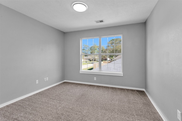 carpeted empty room with a textured ceiling