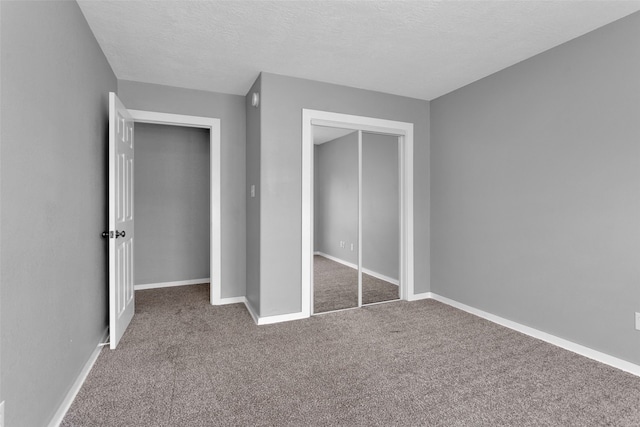 unfurnished bedroom with carpet flooring, a textured ceiling, and a closet