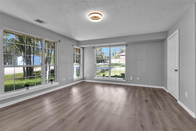 509 Spruce Dr, Conroe, TX 77302 - empty room featuring wood finished floors, a textured ceiling, and baseboards