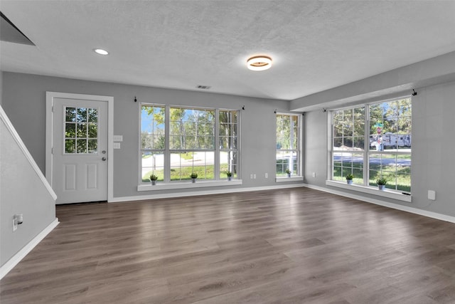 509 Spruce Dr, Conroe, TX 77302 - unfurnished living room featuring baseboards, plenty of natural light, a textured ceiling, wood finished floors, and recessed lighting