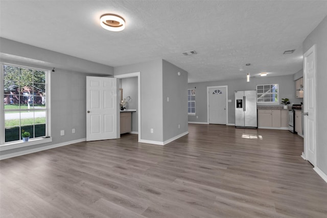 509 Spruce Dr, Conroe, TX 77302 - unfurnished living room featuring baseboards, wood finished floors, and a textured ceiling