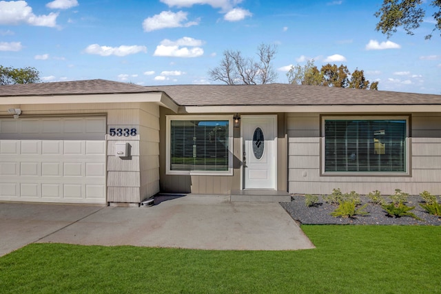 view of front of property with a front lawn and a garage