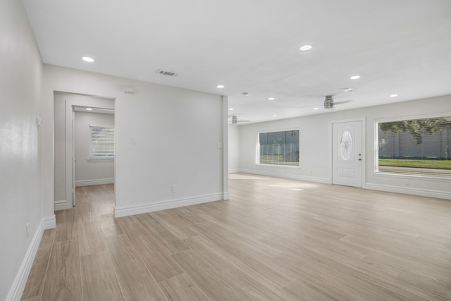 unfurnished living room featuring ceiling fan and light wood-type flooring