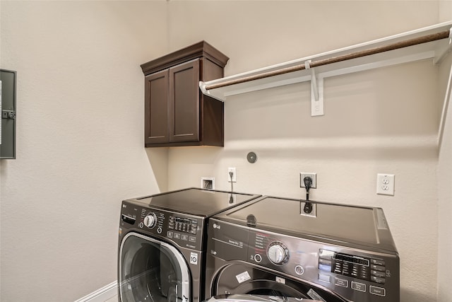 washroom featuring cabinets and washing machine and clothes dryer