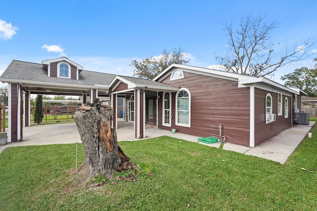 view of front of house with a front yard, a carport, cooling unit, and central air condition unit