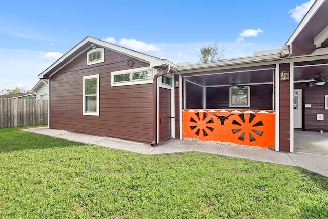 view of side of home with a lawn and a sunroom